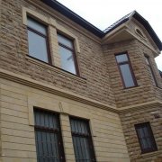 Menghadap fasad rumah dengan bata dan batu: jubin dan panel termal