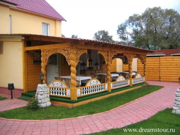 Finition extérieure: porche en bois avec éléments sculptés
