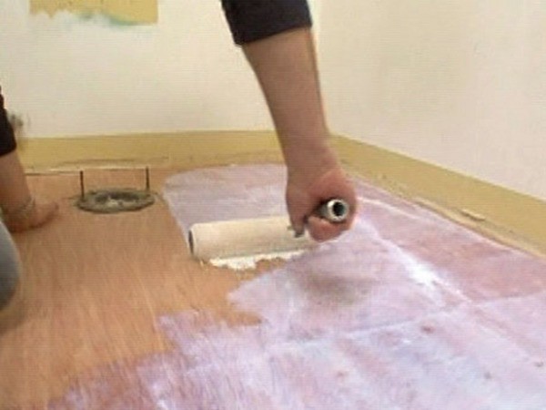 Sur la photo - le processus d'amorçage d'un plancher en bois sous linoléum