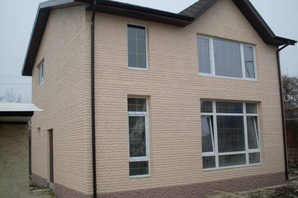 De frente para a casa (fachada) com um tijolo com uma superfície de concreto projetado
