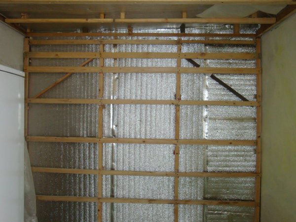 Nous voyons un exemple d'un cadre en bois fait maison pour le revêtement mural avec des cloisons sèches, pour l'isolation et l'isolation acoustique