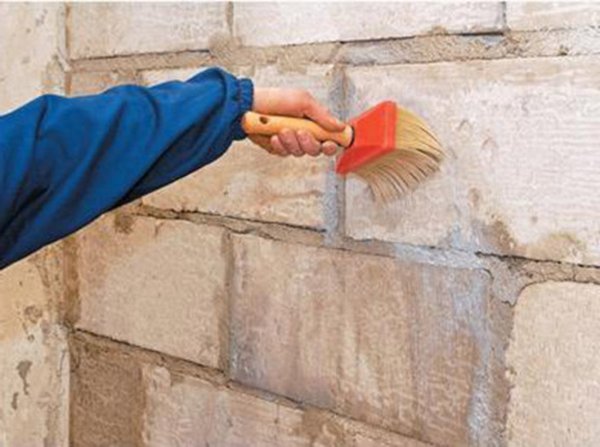 Bức ảnh cho thấy quá trình chuẩn bị các bức tường gạch với một thành phần đặc biệt, trước khi dán chúng bằng các tấm thạch cao