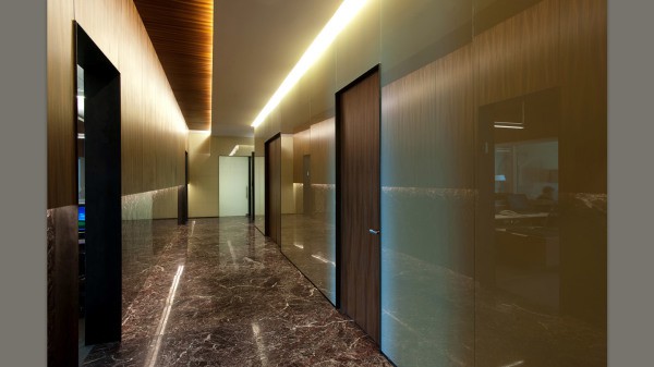 Zdjęcie pokazuje przykład, jak ozdobić ściany korytarza plastikowymi panelami, wizualnie powiększając przestrzeń błyszczącą powierzchnią i podświetleniem