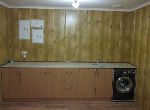 Foto itu menunjukkan contoh menghias dinding dapur dengan panel MDF, yang kelihatan estetik dan cukup mulia, mengingatkan pada hiasan kayu, tetapi jauh lebih murah