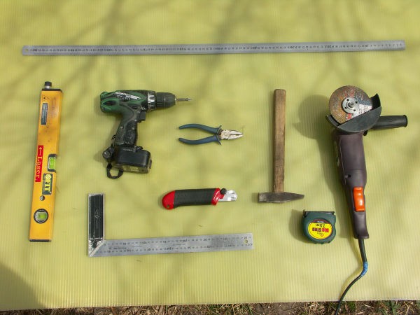 La photo montre un ensemble approximatif d'outils dont vous pourriez avoir besoin pour installer des cloisons sèches sur les murs.
