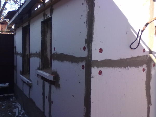 Na fotografii vidíte příklad opláštění starého cihlového domu s sádrokartonovými deskami pomocí plastových hmoždinek