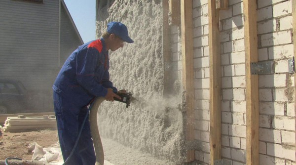 Pulvérisation d'isolant en mousse de polyuréthane sur les murs d'une maison