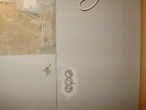 Het proces van het rechtstreeks plakken van muren met gipsplaten, waarachter u de draden gemakkelijk kunt verbergen