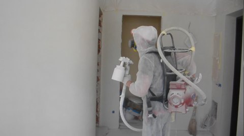 Sienų dažymo procesas naudojant kompresorių ant pečių