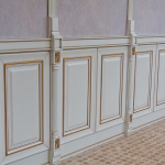One tier boiserie with vertical slats, on a decoratively plastered wall