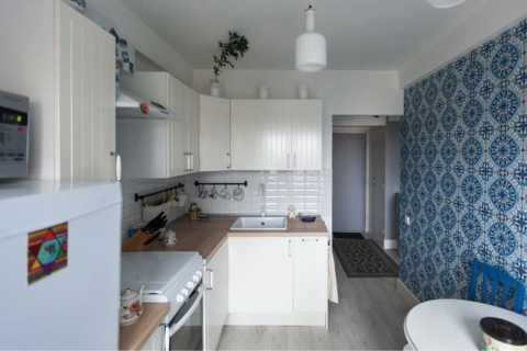Cozinha branca sobre um fundo de papel de parede azul