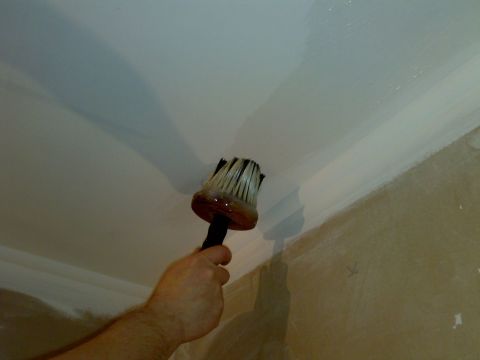 While the finishing material is impregnated, apply the adhesive to the ceiling.
