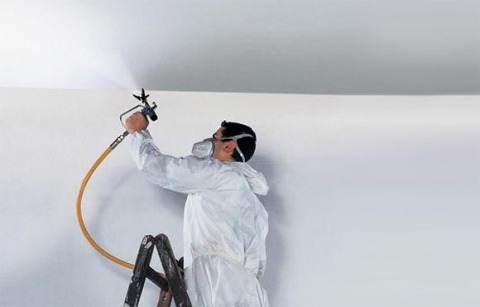 Painting the ceiling with a spray gun.
