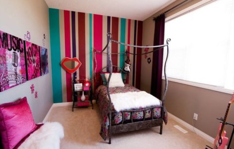 A bright accent wall with vertical stripes will make the room taller