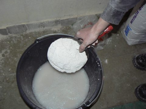 Ανάμιξη στόκου: ο γύψος χύνεται σε ένα δοχείο με καθαρό νερό